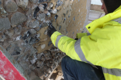 Re-pointing with a lime-based mortar, which will allow trapped moisture to evaporate and the tower to dry out